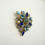 Vintage bloemenbroche met blauwe kristallen en parels