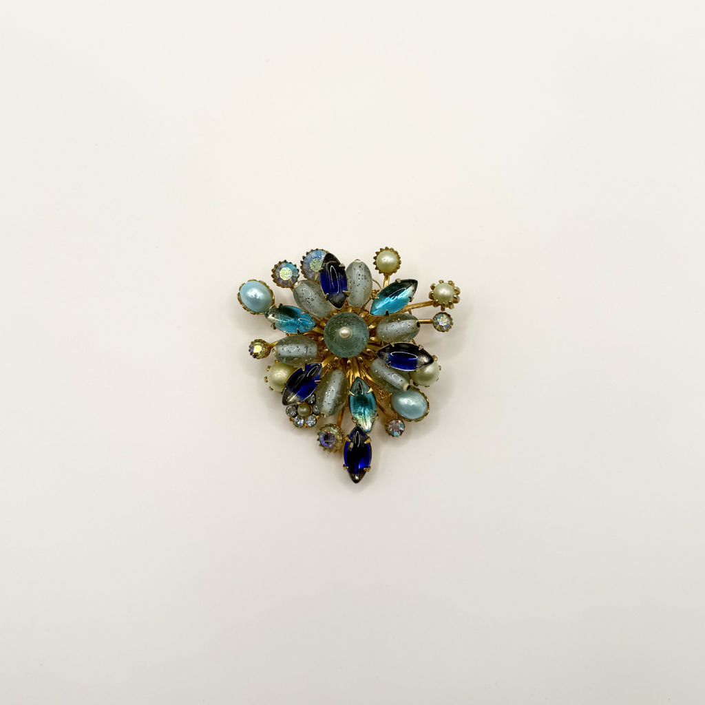 Vintage bloemenbroche met blauwe kristallen en parels